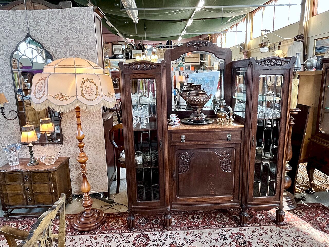 Display cabinets of antique china, teapots and a samovar in an antiques shop